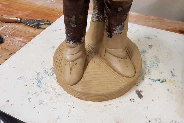 Boetseren van de nieuwe voeten van klei.