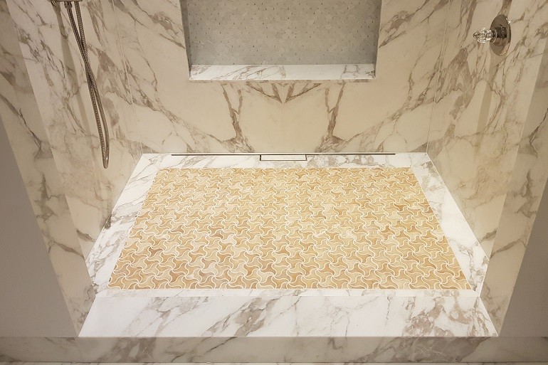 Carrara Bianco Calacatta badkamer bouwen met douche, wasbak en plinten.