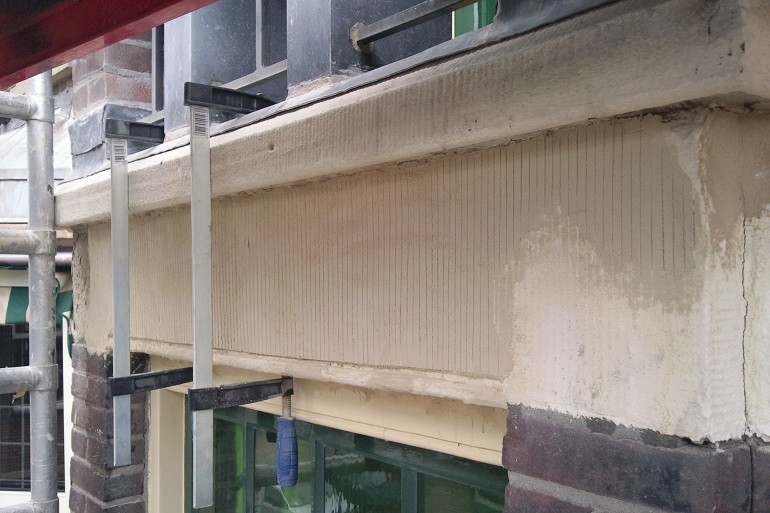 Zandstenen gevelband na restauratie